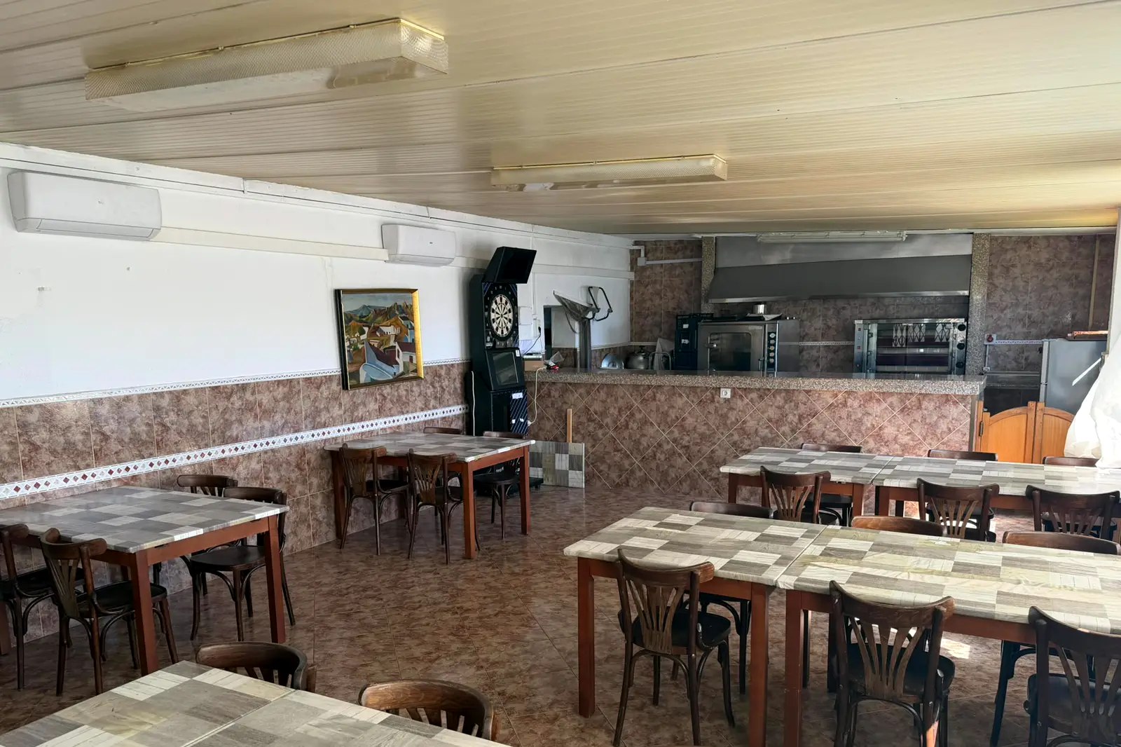 El comedor de El Rocío, con mesas para grupos y la cocina al fondo